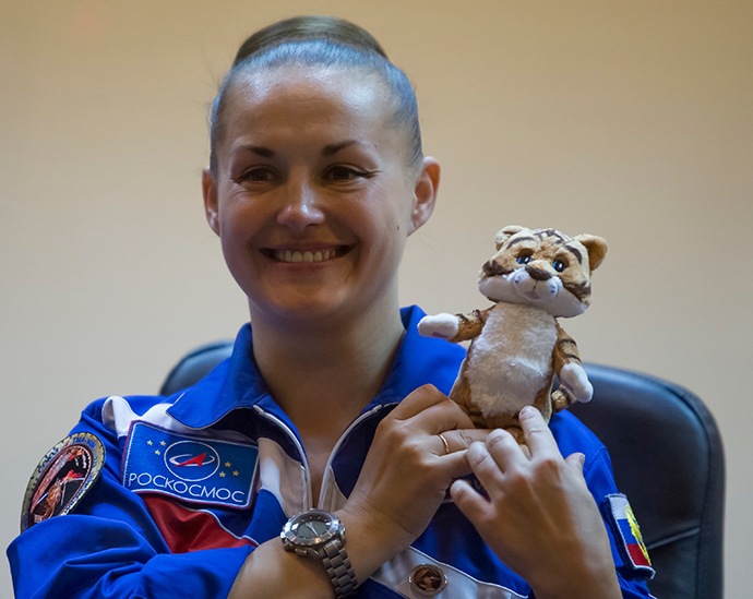 The International Space Station crew member Elena Serova of Russia holds a soft toy, that will be taken to the station, during a news conference behind a glass wall at Baikonur cosmodrome September 24, 2014 (Reuters / Shamil Zhumatov)