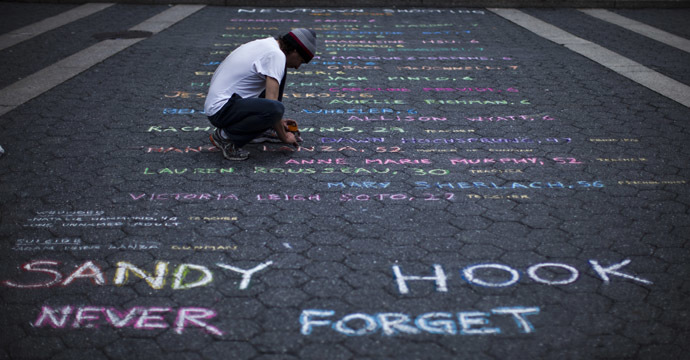 Street artist Mark Panzarino, 41, prepares a memorial as he writes the names of the Sandy Hook Elementary School victims during the six-month anniversary of the massacre, at Union Square in New York, June 14, 2013. (Reuters/Eduardo Munoz)