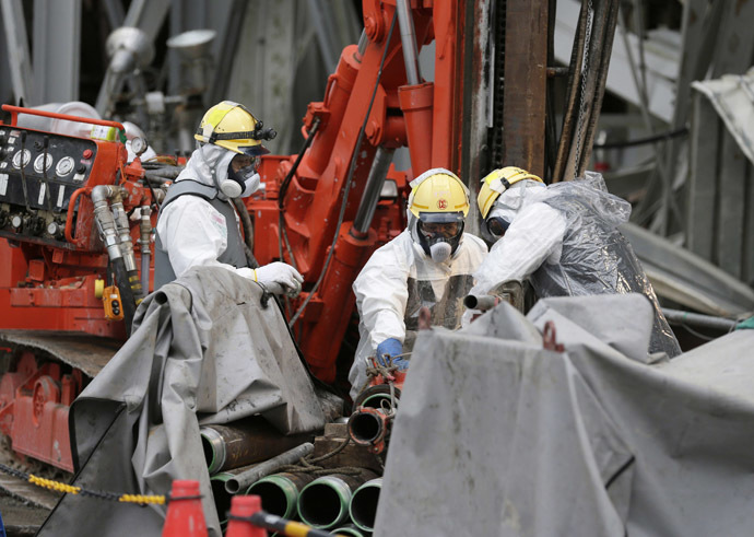 Workers conduct operations to construct an underground ice wall at Tokyo Electric Power Co.'s (Tepco) tsunami-crippled Fukushima Daiichi nuclear power plant in Fukushima Prefecture July 9, 2014. (Reuters/Kimimasa Mayama)