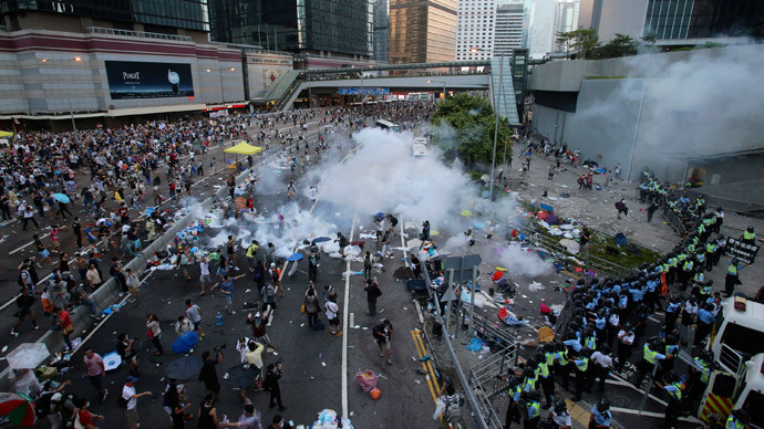Riot police fire teargas to disperse protesters, during clashes after thousands of protesters blocked the main street to the financial Central district (background) outside the government headquarters in Hong Kong September 28, 2014.(Reuters / Stringer)