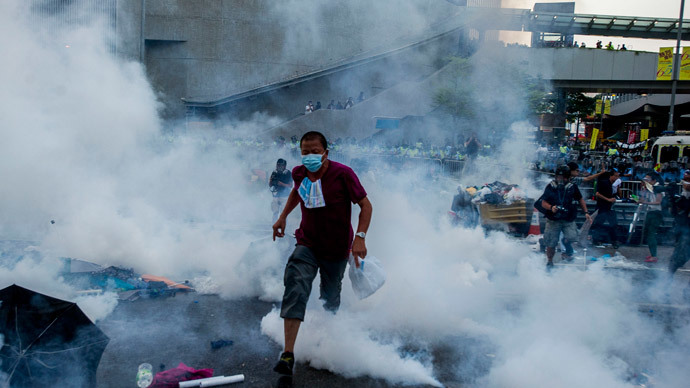 A pro-democracy demonstrator runs as police fired tear gas towards protesters near the Hong Kong government headquarters on September 28, 2014.(AFP Photo / Xaume Olleros)