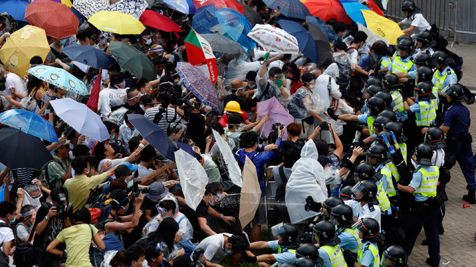 Protesters take cover from pepper spray with umbrellas as riot police clash with tens of thousands of protesters blocking the main street leading to the financial Central district outside the government headquarters in Hong Kong September 28, 2014.(Reuters / Bobby Yip)