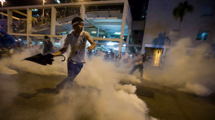 A protester throws an umbrella at riot police as fellow demonstrators blocked the main street to the financial Central district outside the government headquarters in Hong Kong September 29, 2014.(Reuters / Tyrone Siu)