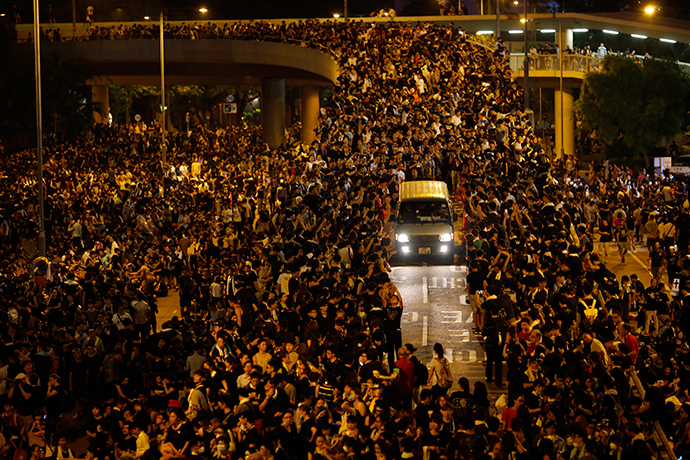 A vehicle drives among protesters blocking the main street to the financial Central district, outside the government headquarters, in Hong Kong September 29, 2014. (Reuters / Carlos Barria)