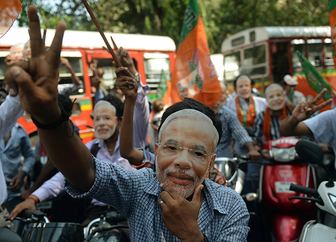 India's Bharatiya Janata Party (BJP) supporters wear masks of prime minister-designate Narendra Modi during a celebration rally in Mumbai on May 26, 2014. (AFP Photo / Punit Paranjpe)