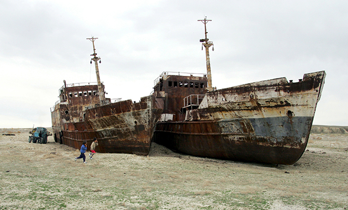 Children run past ruined ships abandoned in sand that once formed the bed of the Aral Sea near the village of Zhalanash, in southwestern Kazakhstan (Reuters / Shamil Zhumatov / Files)