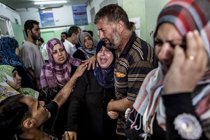 Palestinian relatives cry at the Kamal Adwan hospital in Beit Lahia following an Israeli army shelling in a UN school on July 30, 2014. (AFP Photo/Marco Longari)