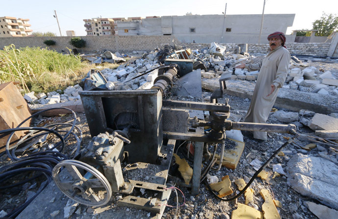 Abu Ismail, the owner of a plastics factory that was targeted on Sunday by what activists said were U.S.-led air strikes, gestures while standing at his destroyed factory in the Islamic State's stronghold of Raqqa September 29, 2014. (Reuters/Stringer)