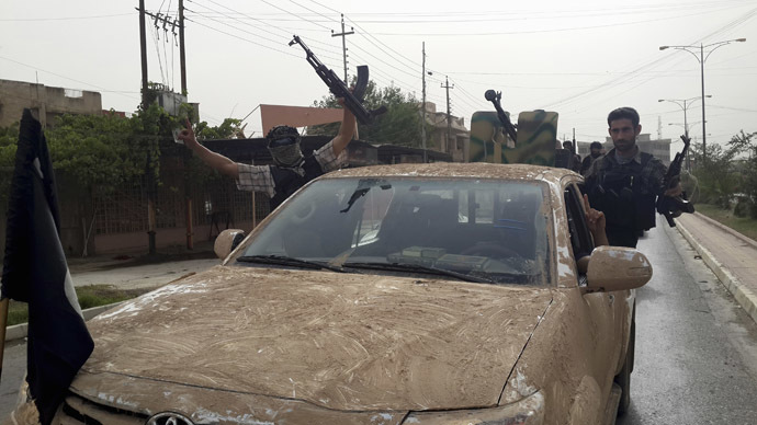 Fighters of the Islamic State of Iraq and the Levant (ISIL) celebrate on vehicles taken from Iraqi security forces, at a street in city of Mosul, June 12, 2014. (Reuters/Stringer)