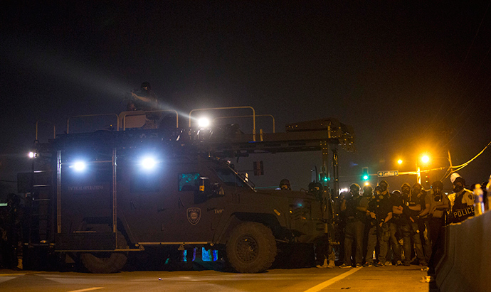 Police officers keep watch while demonstrators (not pictured) protest the death of black teenager Michael Brown in Ferguson, Missouri August 12, 2014 (Reuters / Mario Anzuoni)