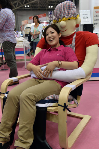 An employee of Japan's nursing care goods maker Unicare demonstrates an easy chair for congnitively empaired persons "Yasuragi chair" at the annual International Home care and Rehabilitation exhibition in Tokyo on October 1, 2014. (AFP Photo)