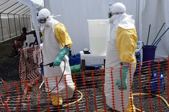A health worker in protective suit carries equipment on October 1, 2014 at MSF's (Doctors Without Borders) Ebola treatment center in Monrovia. (AFP Photo)