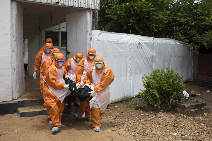 A burial team wearing protective clothes, remove a body from an isolation holding centre, for people waiting for laboratory results, at the Port Loko District Hospital September 27, 2014. (Reuters/Christopher Black/WHO)
