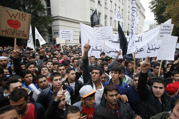 Austrian Muslims carry banners and shout slogans during a protest against a film made in the U.S. and cartoons published by a French magazine that denigrate Islam's Prophet Mohammad, in Vienna September 22, 2012. (Reuters/Leonhard Foeger)