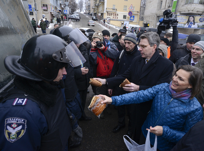 U.S. Assistant Secretary of State for European and Eurasian Affairs Victoria Nuland (R) and U.S. Ambassador Geoffrey Pyatt (2nd R) distribute bread to riot police near Independence square in Kiev December 11, 2013. (Reuters / Andrew Kravchenko)