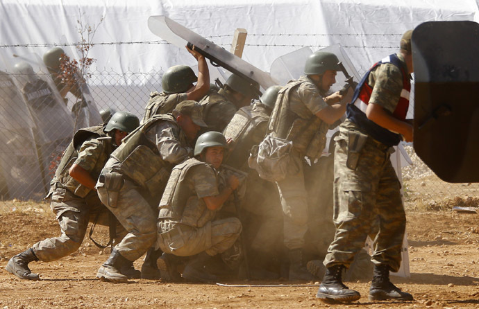 Turkish soldiers take cover from stone throwing Turkish Kurdish protesters near the Mursitpinar border crossing on the Turkish-Syrian border in the Turkish town of Suruc in southeastern Sanliurfa province October 4, 2014. (Reuters/Murad Sezer)