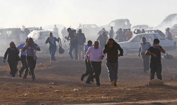 Turkish Kurdish protesters run from tear gas fired by Turkish soldiers near the Mursitpinar border crossing on the Turkish-Syrian border, in the Turkish town of Suruc in southeastern Sanliurfa province October 4, 2014. (Reuters/Murad Sezer)
