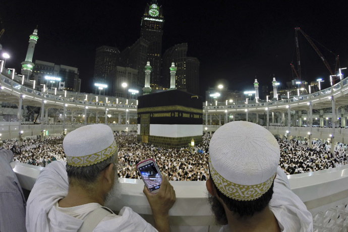 Muslim pilgrims take pictures for the pilgrims as they pray around the holy Kaaba at the Grand Mosque, during the annual haj pilgrimage in Mecca October 1, 2014. (Reuters/Muhammad Hamed)