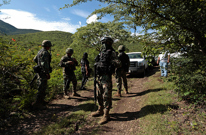 Soldiers guard an area where a mass grave was found, in Colonia las Parotas on the outskirts of Iguala, in Guerrero October 4, 2014 (Reuters / Jorge Dan Lopez)