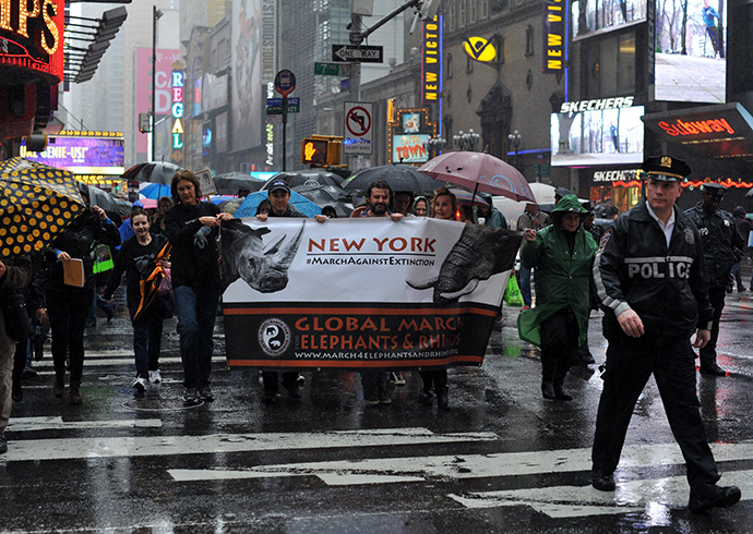 Protesters march across 42nd Street during the official Global March for Elephants and Rhinos rally in New York on October 4, 2014 (Reuters / Timothy A. Clary)