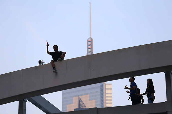 A man who said his three children couldn't go to school because of road blockages brought on by the occupy movement sits in protest on top of a pedestrian bridge in Hong Kong on October 5, 2014 (AFP Photo / Aaron Tam)