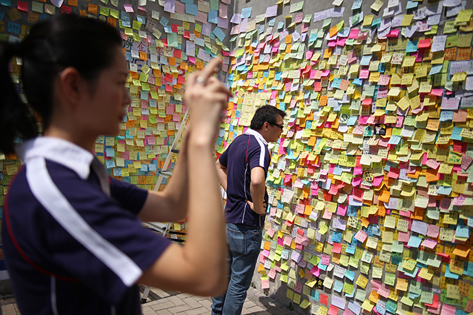 People look at sticky notes containing messages in support of the pro-democracy protests, near the Hong Kong government headquarters on October 5, 2014 (AFP Photo / Aaron Tam)