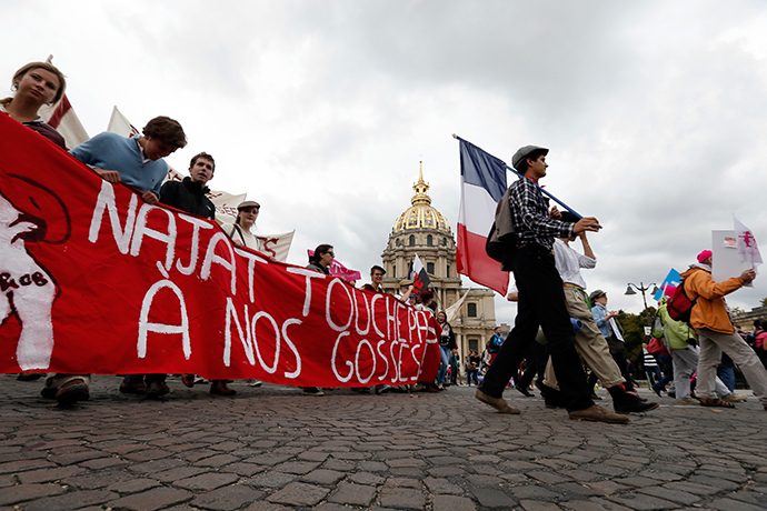 People walk behind a banner as tens of thousands of demonstrators take part in the "Manif Pour Tous" (Demonstration For All) to protest against PMA (Procreation Medicalement Assistee or Medically Assisted Reproduction) and GPA (Grosesse pour Autrui or Gestation for Others) during a march in Paris October 5, 2014 (Reuters / Gonzalo Fuentes)