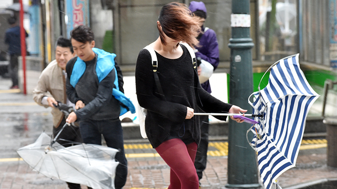 Pedestrians walk against strong wind and rain in Tokyo on October 6, 2014 (AFP Photo / Yoshikazu Tsuno)