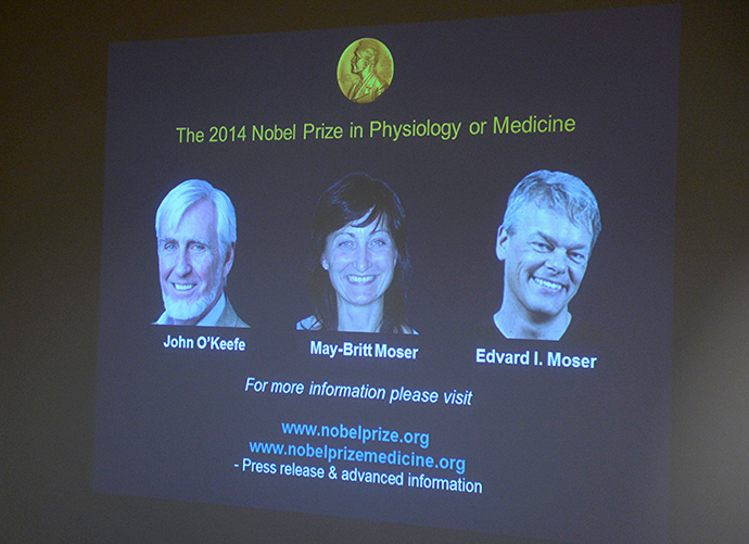 A screen presents the winners of the Nobel Prize in Medicine, U.S.-British scientist John O'Keefe and Norwegian husband and wife Edvard Moser and May-Britt Moser for their discoveries of cells that constitute a positioning system in the brain, at the Karolinska Institute in Stockholm October 6, 2014 (Reuters / Bertil Ericson)