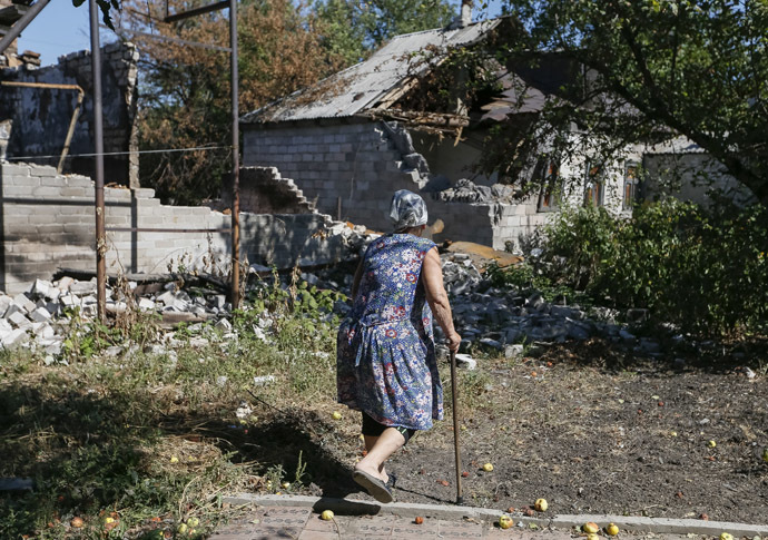 A local woman passes by near her residence which was damaged during fighting between the Ukrainian army and pro-Russian separatists, in Pervomayskoe near Donetsk September 6, 2014. (Reuters/Gleb Garanich)