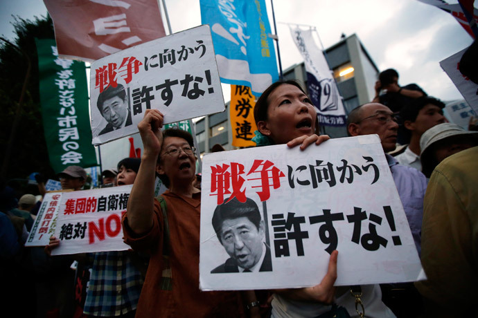 Protesters shout slogans as they hold placards during a rally against Japan's Prime Minister Shinzo Abe's push to expand Japan's military role, in front of Abe's official residence in Tokyo July 1, 2014. (Reuters / Issei Kato)