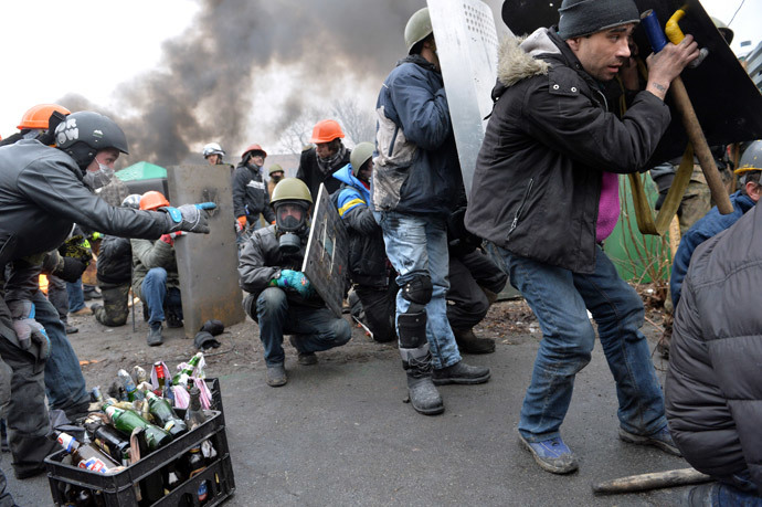 Anti-government protesters take cover during clashes with riot police in central Kiev on February 20, 2014.(AFP Photo / Sergei Supinsky)