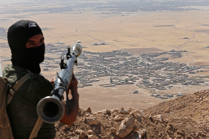A Kurdish Peshmerga fighter holds a a rocket-propelled grenade launcher as he takes up position in an area overlooking Baretle village (background), which is controlled by the Islamic State, in Khazir, on the edge of Mosul September 8, 2014 (Reuters / Ahmed Jadallah)