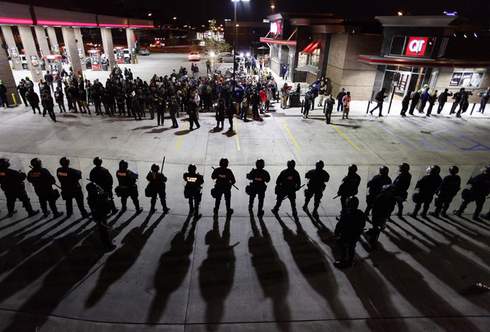 Police officers in riot gear hold a line as they watch demonstrators protest the shooting death of Michael Brown and 18-year-old Vonderrit Myers Jr. at a QuikTrip convince store and gas station October, 12 2014 in St. Louis, Missouri. (AFP Photo/Joshua Lott)