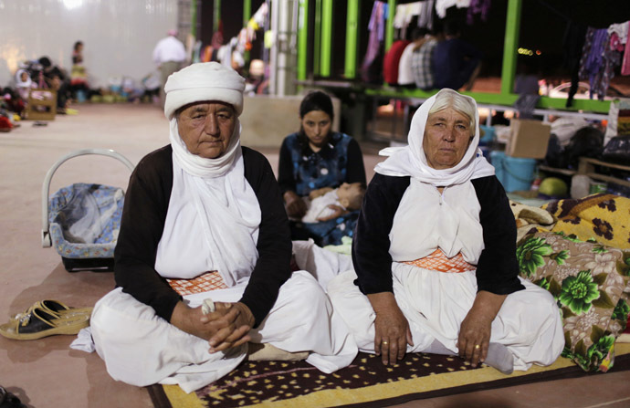 Women from the minority Yazidi sect, who fled violence in the Iraqi town of Sinjar, sit on the ground in an abandoned warehouse in Dohuk province August 22, 2014. (Reuters/Youssef Boudlal)