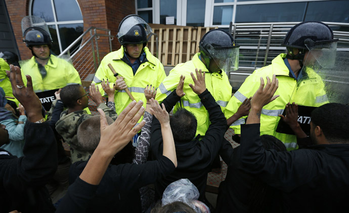 Protestors hold up their hands as the riot police move in during a protest at the Ferguson Police Department in Ferguson, Missouri, October 13, 2014. (Reuters/Jim Young)