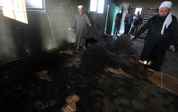 Palestinian Muslim clerics inspect the inside of a mosque allegedly burnt by Jewish settlers, in the village of Aqraba, in the Israeli occupied Palestinian West Bank, near the northen city of Nablus, on October 14, 2014. (AFP Photo / Jaafar Ashtiyeh)