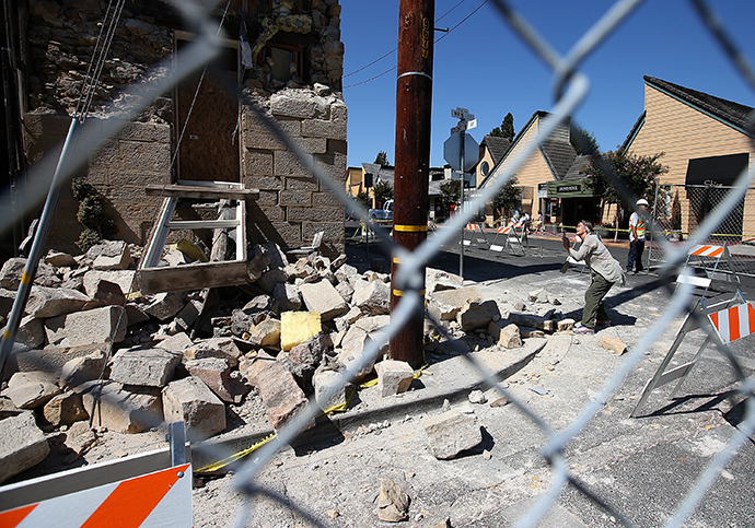 A passerby stops to take a picture of the earthquake-damaged Vintner's Collective building on August 26, 2014 in Napa, California. (Justin Sullivan / Getty Images / AFP)