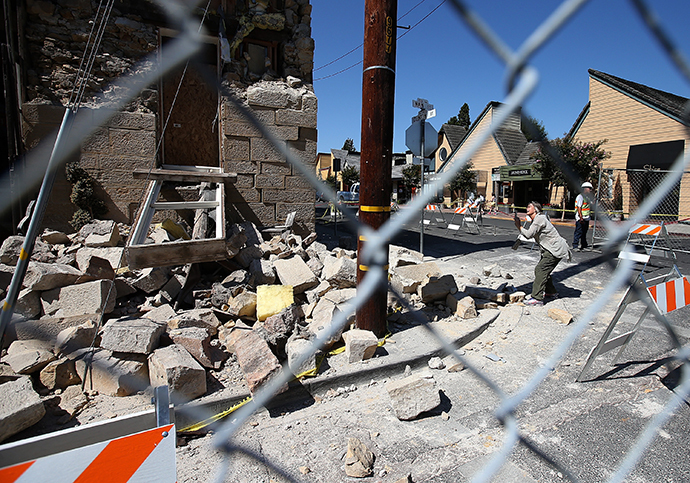 A passerby stops to take a picture of the earthquake-damaged Vintner's Collective building on August 26, 2014 in Napa, California. (Justin Sullivan / Getty Images / AFP) 