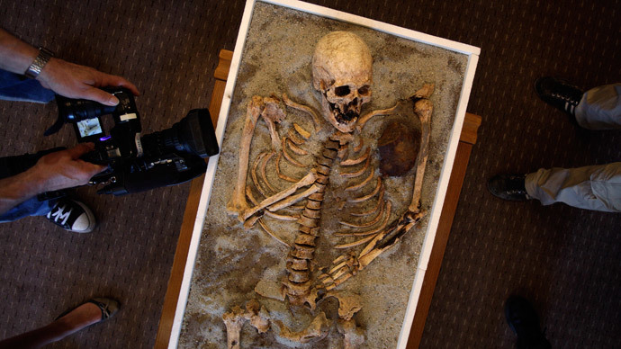 Members of the media surround a skeleton pierced with a piece of iron, on display during a media event at the National History Museum in Sofia.(Reuters / Stoyan Nenov)