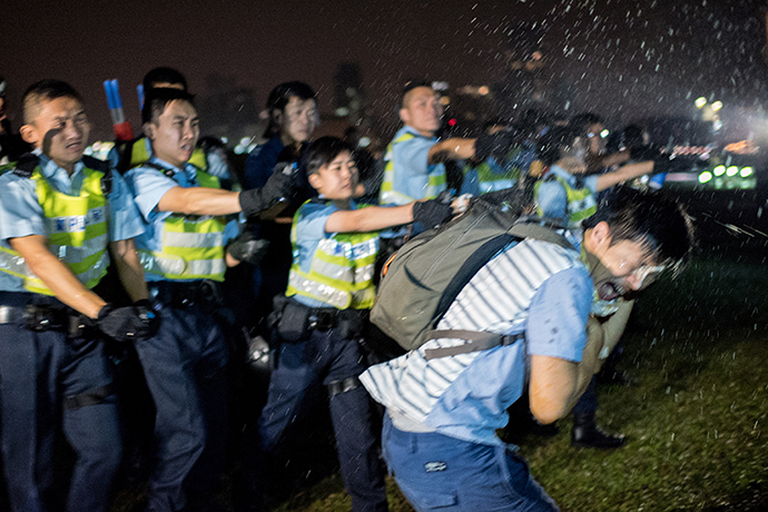 Police officers spray a protester in the face with pepper spray in Hong Kong on October 15, 2014. (AFP Photo / Alex Ogle)