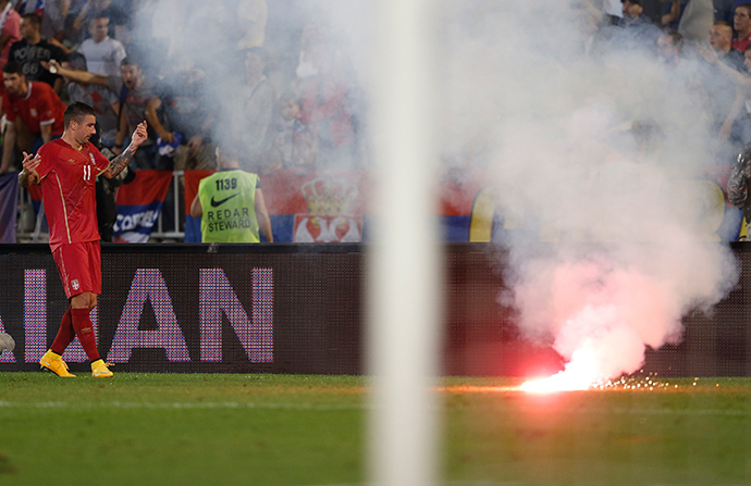 Aleksandar Kolarov of Serbia reacts as flares are thrown to the pitch during their Euro 2016 Group I qualifying soccer match against Albania at the FK Partizan stadium in Belgrade October 14, 2014. (Reuters / Marko Djurica) 
