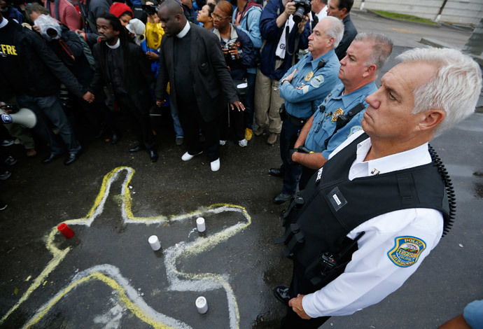 Police officers stand over a chalk outline of a body during a protest at the Ferguson Police Department in Ferguson, Missouri.(Reuters / Jim Young)