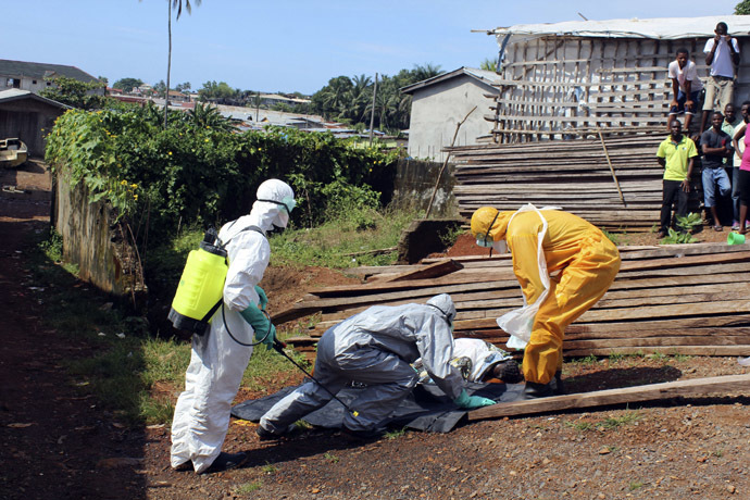 Health workers remove the body a woman who died from the Ebola virus in the Aberdeen district of Freetown, Sierra Leone, October 14, 2014. (Reuters/Josephus Olu-Mammah)