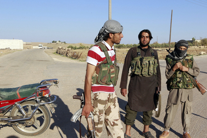 Islamic State fighters stand along a street in the countryside of the Syrian Kurdish town of Kobani, after taking control of the area October 7, 2014. (Reuters / Stringer)