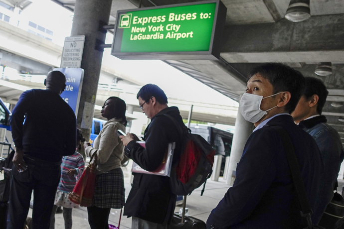 A passenger wears a mask as he exits JFK International Airport in New York. (Reuters/Eduardo Munoz)