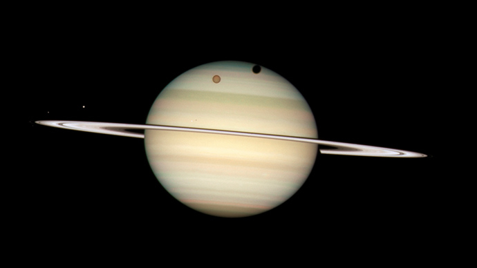 An image of four moons of Saturn passing in front of their parent planet in seen this image taken by NASA's Hubble Space Telescope (Reuters / NASA)