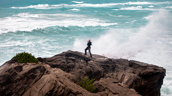 A man takes photos while standing on a cliff on the island's south shore battered by winds from approaching Hurricane Gonzalo, in Astwood Park, October 17, 2014 (Reuters / Nicola Muirhead)