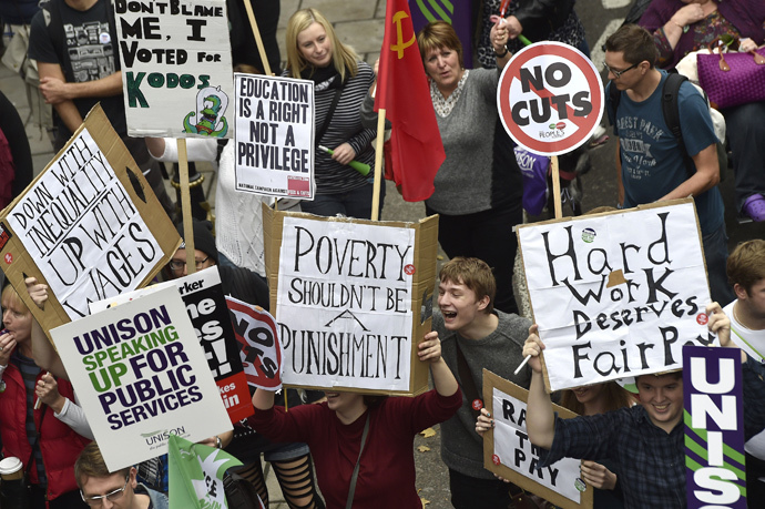 Protestors hold placards as they march through central London, October 18, 2014. (Reuters / Toby Melville)