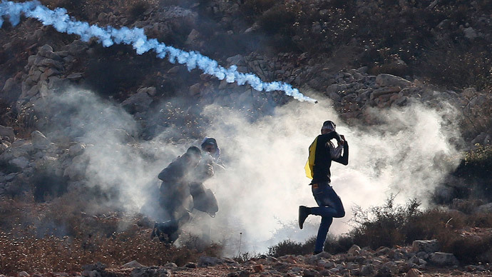 Palestinian protesters run from tear gas fired by Israeli troops during clashes at a protest to show solidarity with al-Aqsa mosque, outside Israel's Ofer military prison near the West Bank city of Ramallah October 17, 2014.(Reuters / Ammar Awad)